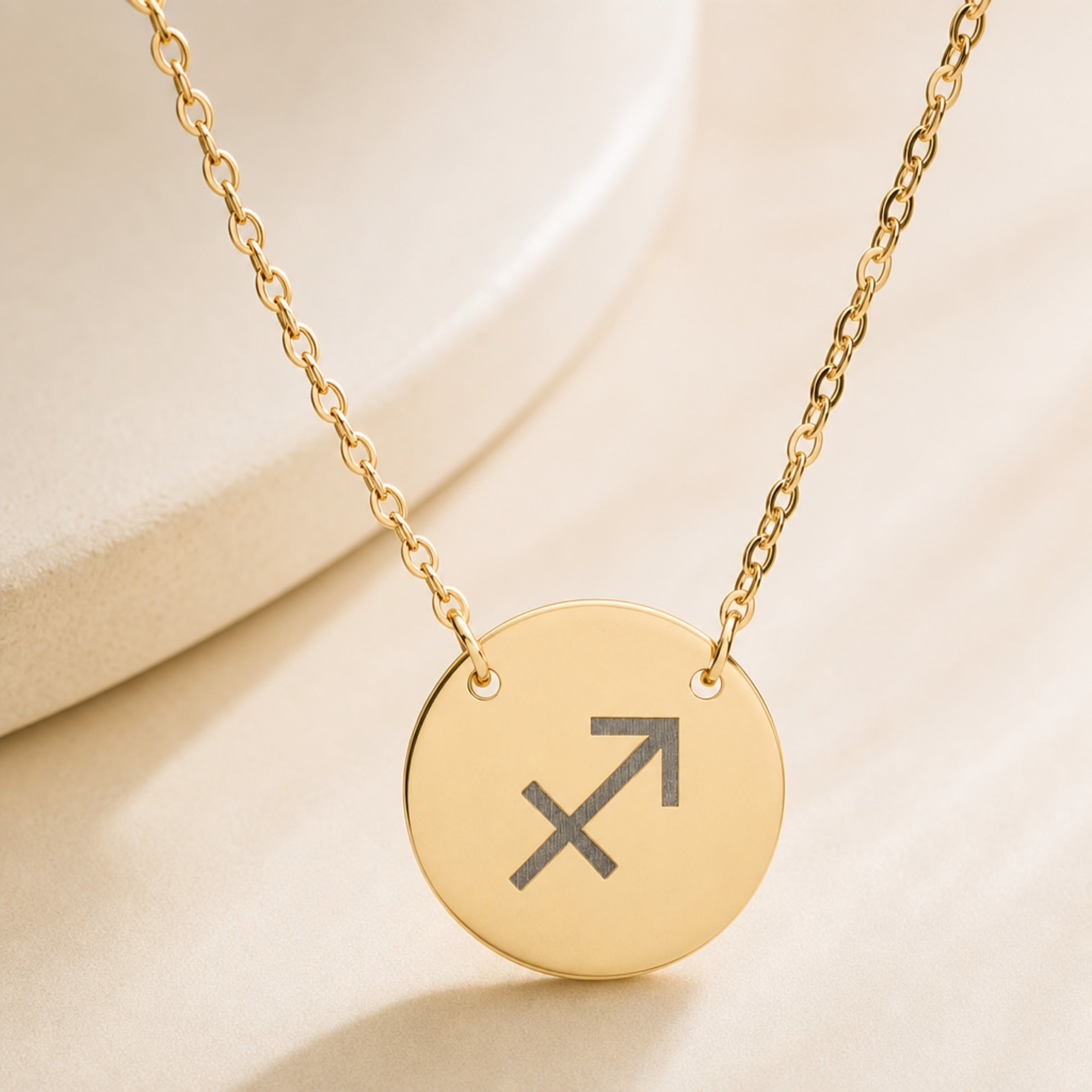 Sagittarius zodiac coin necklace close-up — detail of laser-engraved Sagittarius Archer glyph on 18K gold pendant