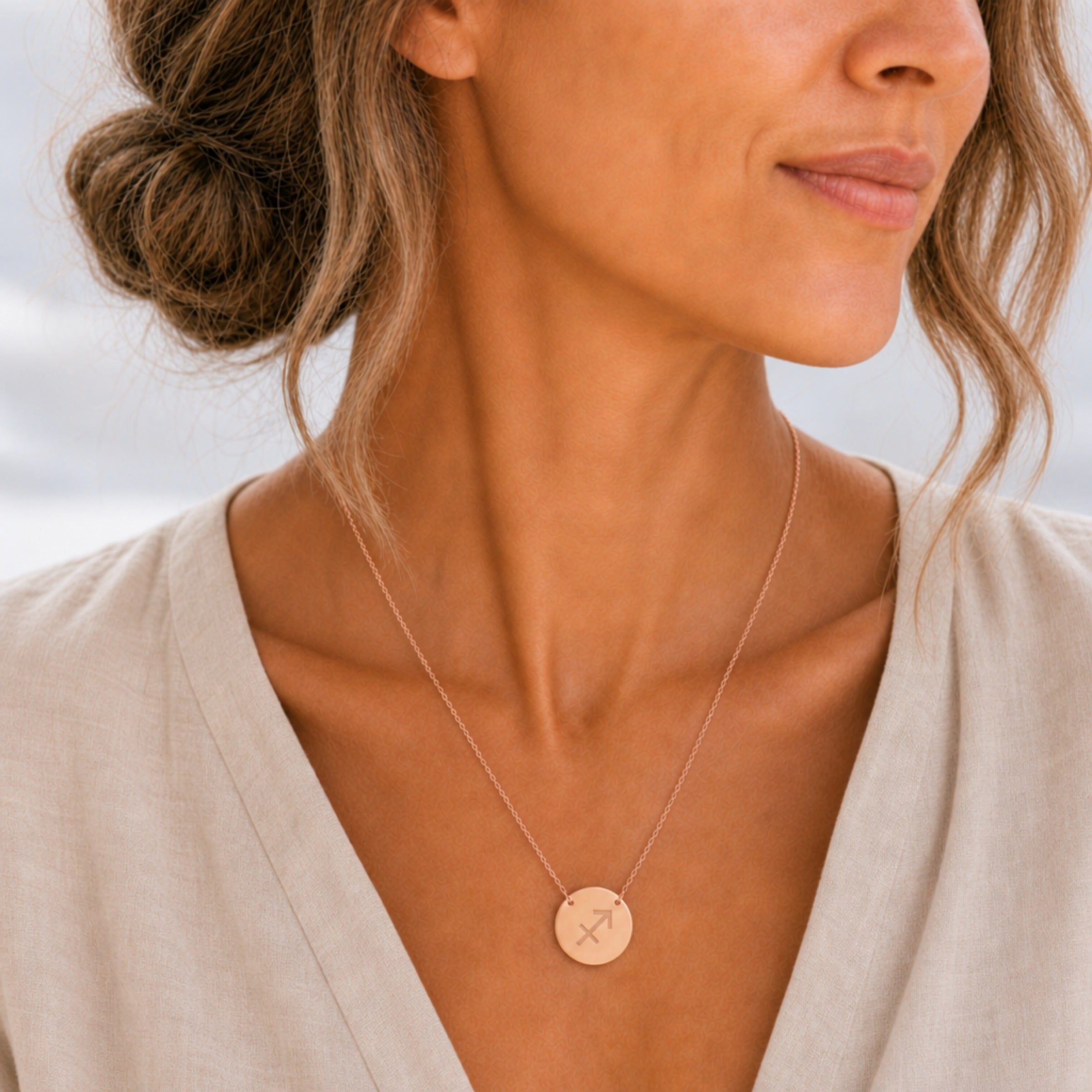 Sagittarius zodiac coin necklace lifestyle — 18K rose gold pendant with laser-engraved Sagittarius Archer glyph worn on model