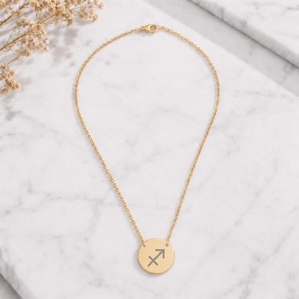 Sagittarius zodiac coin necklace marble flatlay — 18K gold pendant engraved with Sagittarius Archer star sign on white marble with dried floral, premium personalized astrology necklace gift for December birthday, Sagittariusian present