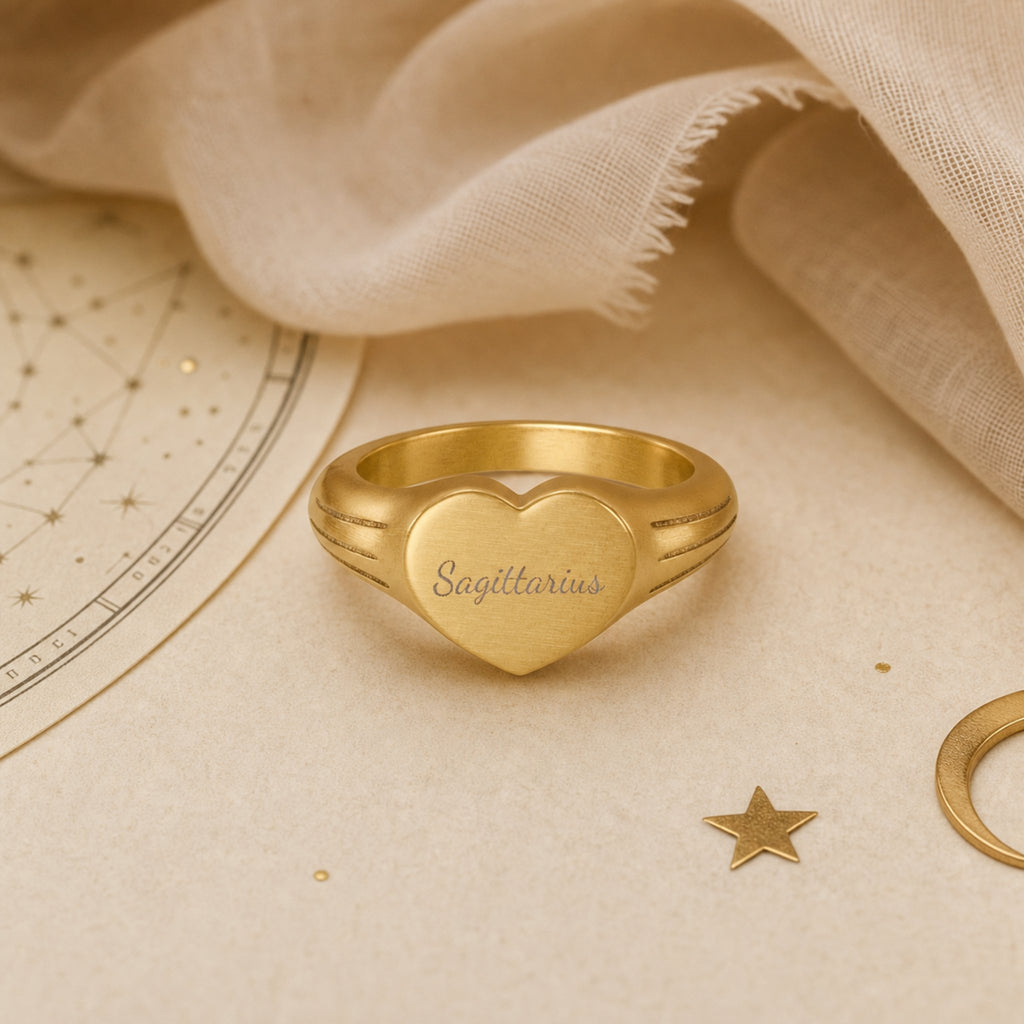 Sagittarius zodiac heart signet ring celestial flatlay — zodiac chart and brass star with engraved Sagittarius heart signet, astrology gift styling