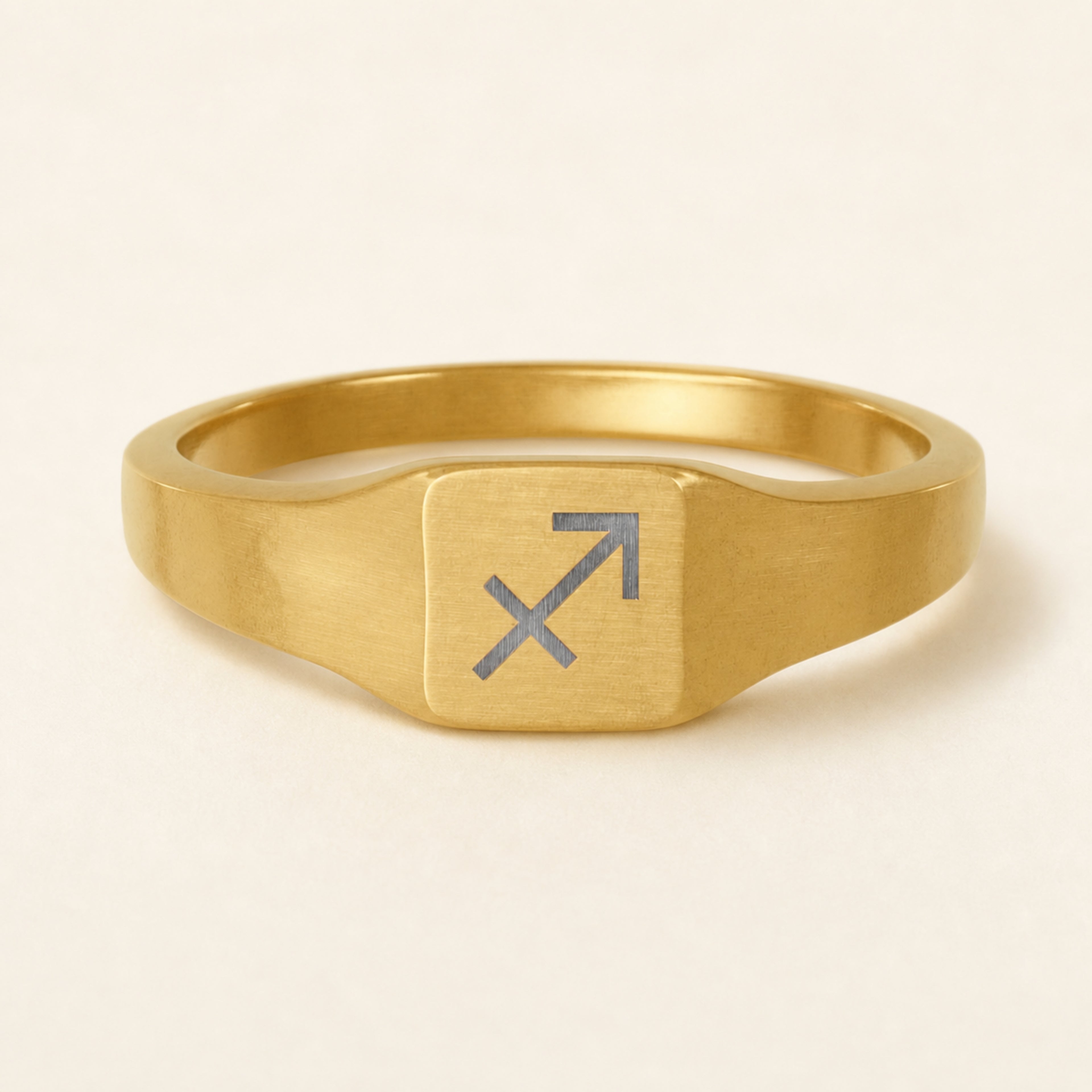 Sagittarius zodiac square signet ring studio front — clean cream backdrop product shot, 18K gold matte PVD