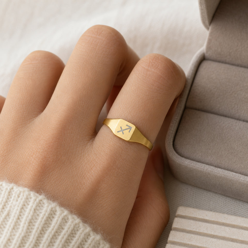 Sagittarius zodiac square signet ring scale-in-hand — fingers holding ring next to gift box and ruler, dainty 20mm signet sizing
