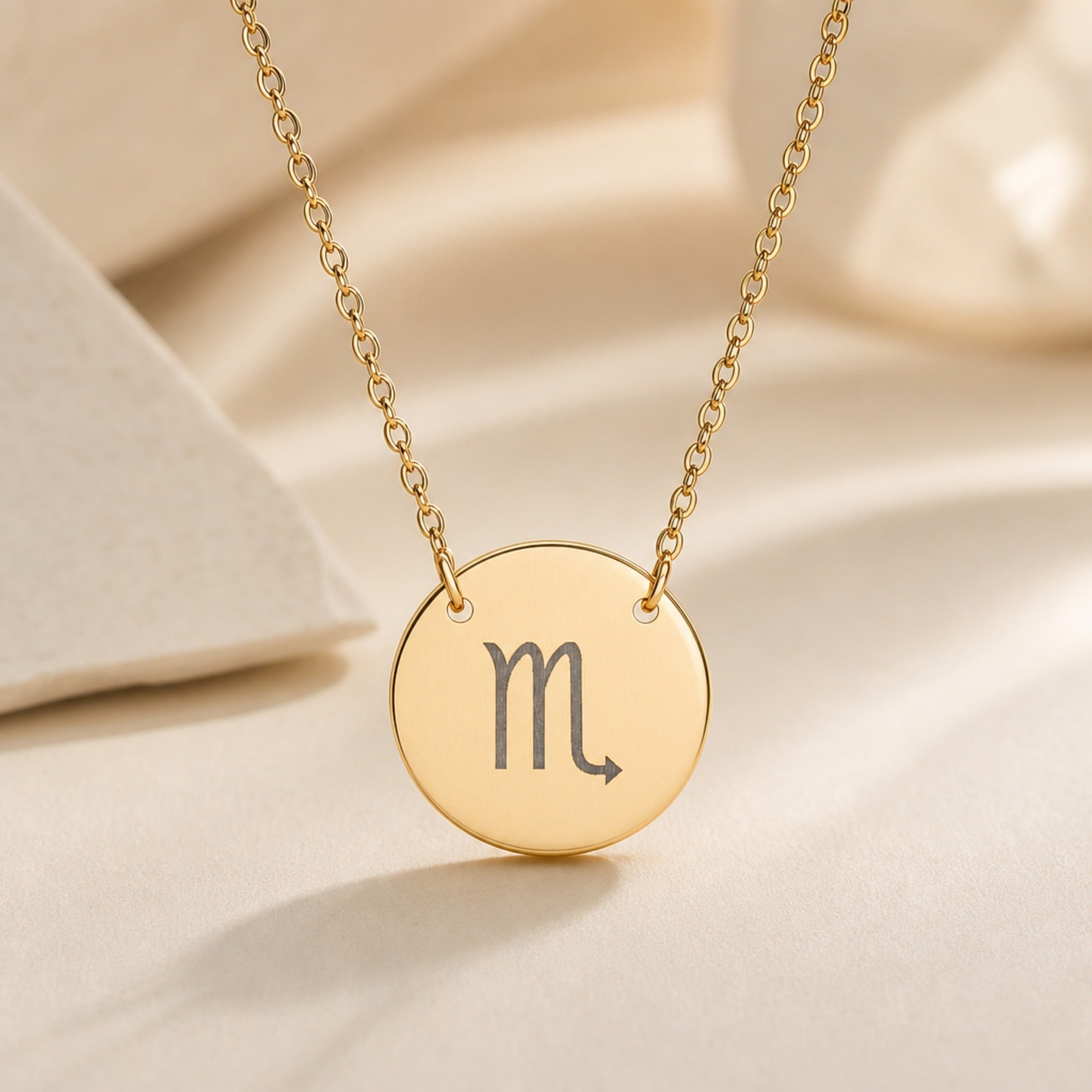 Scorpio Coin Gold zodiac necklace flatlay — 18K gold pendant engraved with Scorpio Scorpion star sign on cream silk, premium personalized astrology necklace gift for November birthday, Scorpio woman, mother, daughter