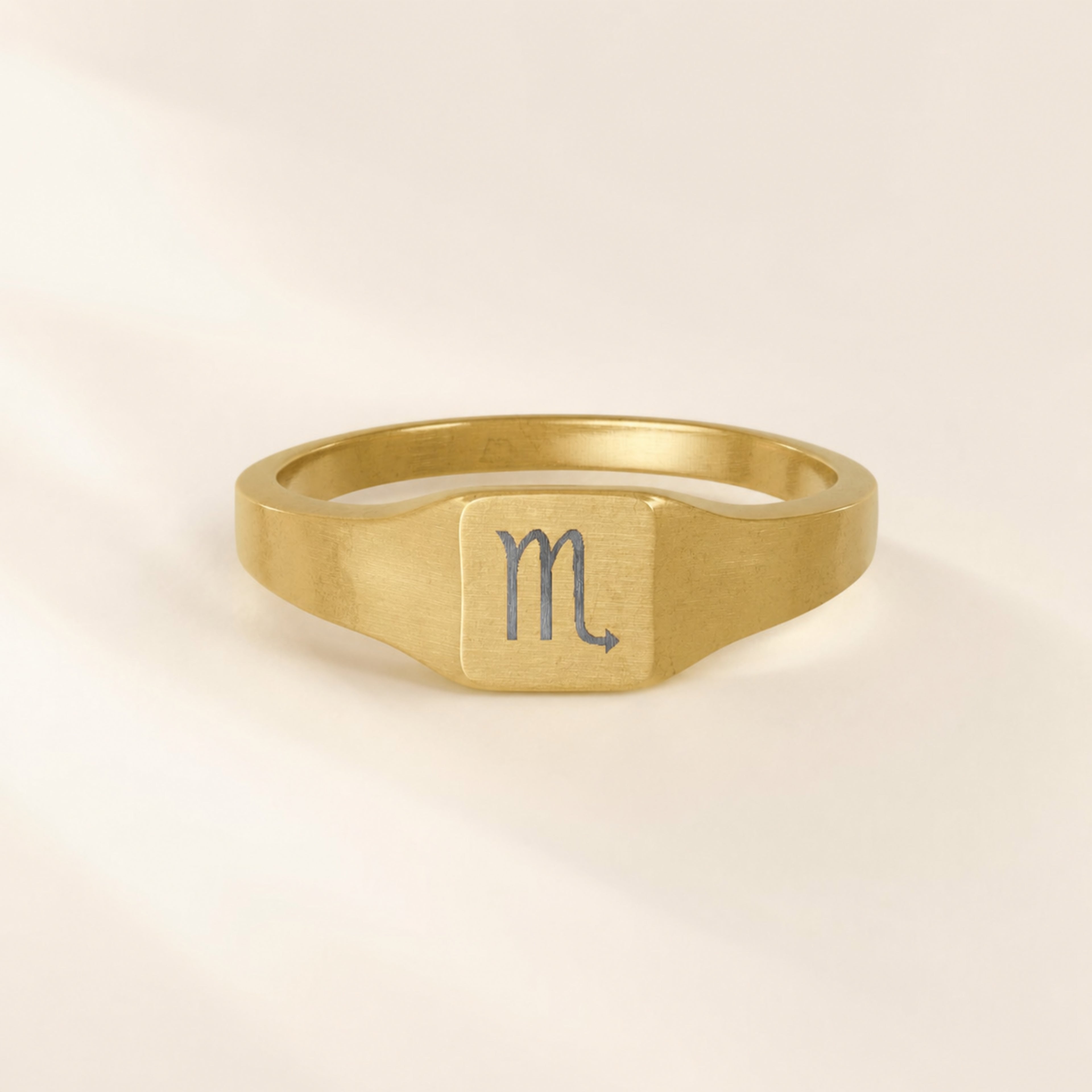 Scorpio zodiac square signet ring engraving close-up — laser-etched Scorpion detail, brushed grey on matte gold