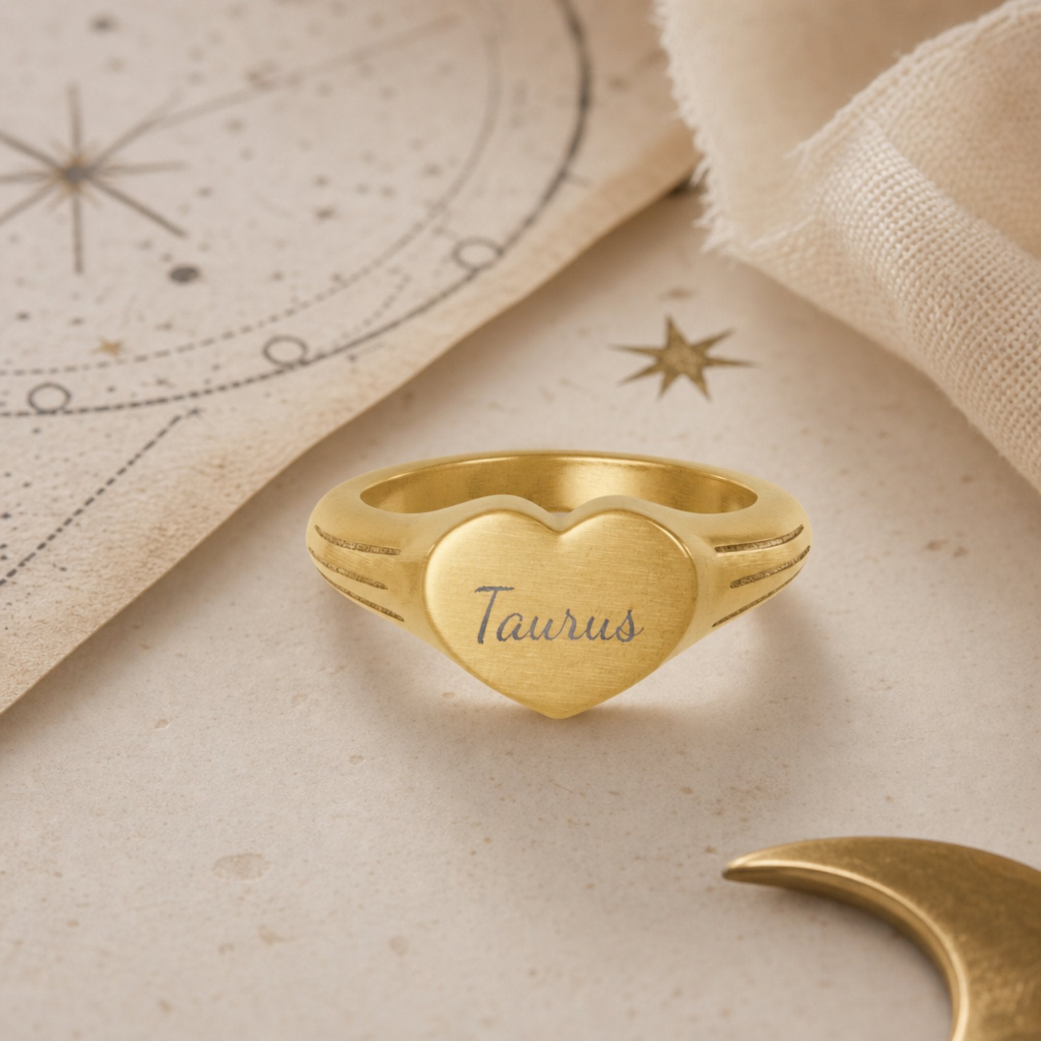 Taurus zodiac heart signet ring celestial flatlay — zodiac chart and brass star with engraved Taurus heart signet, astrology gift styling