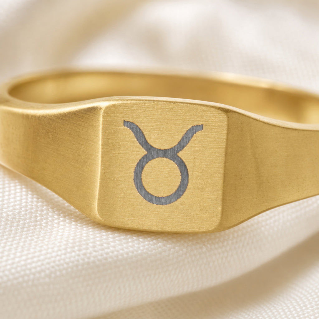 Taurus zodiac square signet ring engraving close-up — laser-etched Bull detail, brushed grey on matte gold