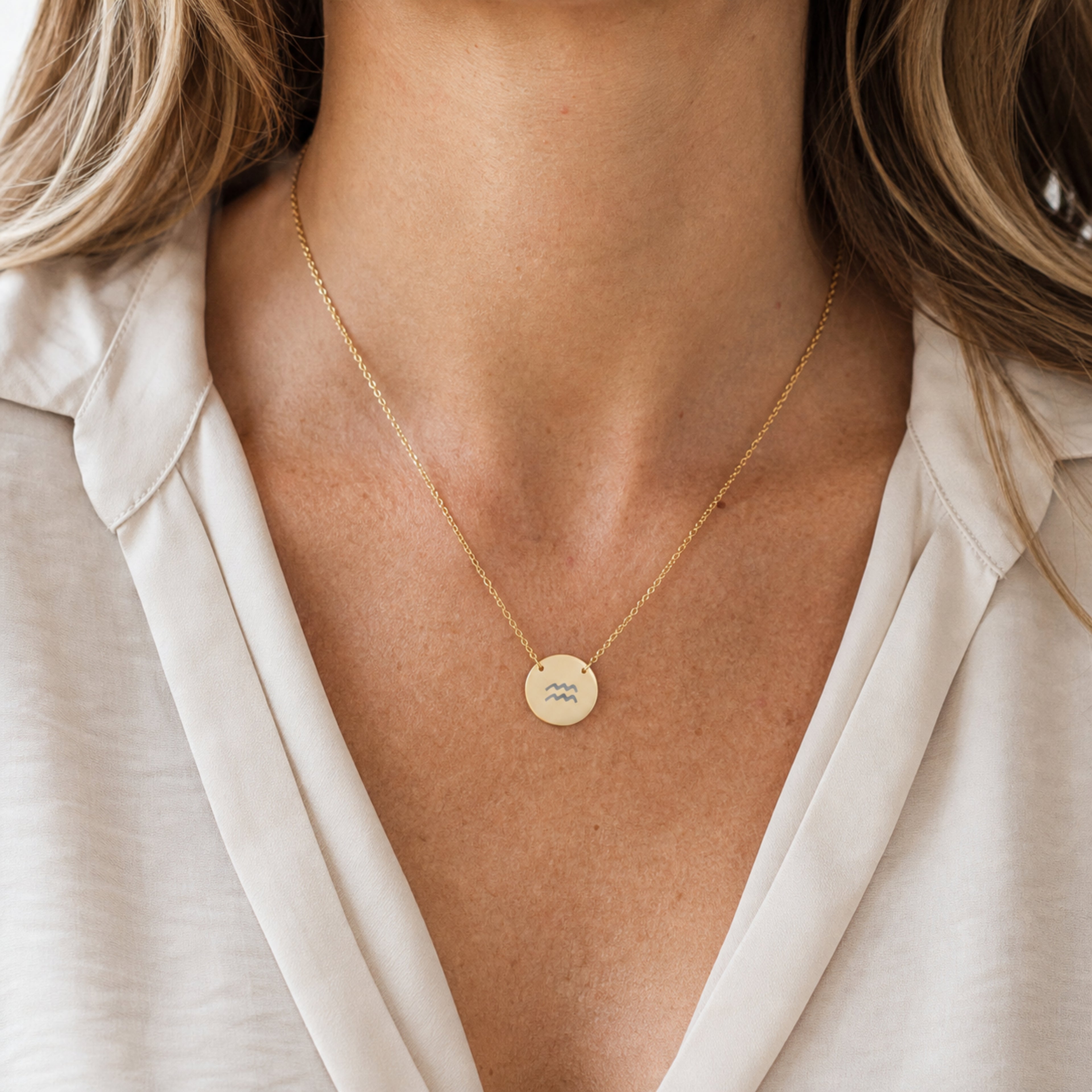 Aquarius zodiac coin necklace worn on model in 18K gold PVD - engraved star sign pendant on neckline (AI-generated image)