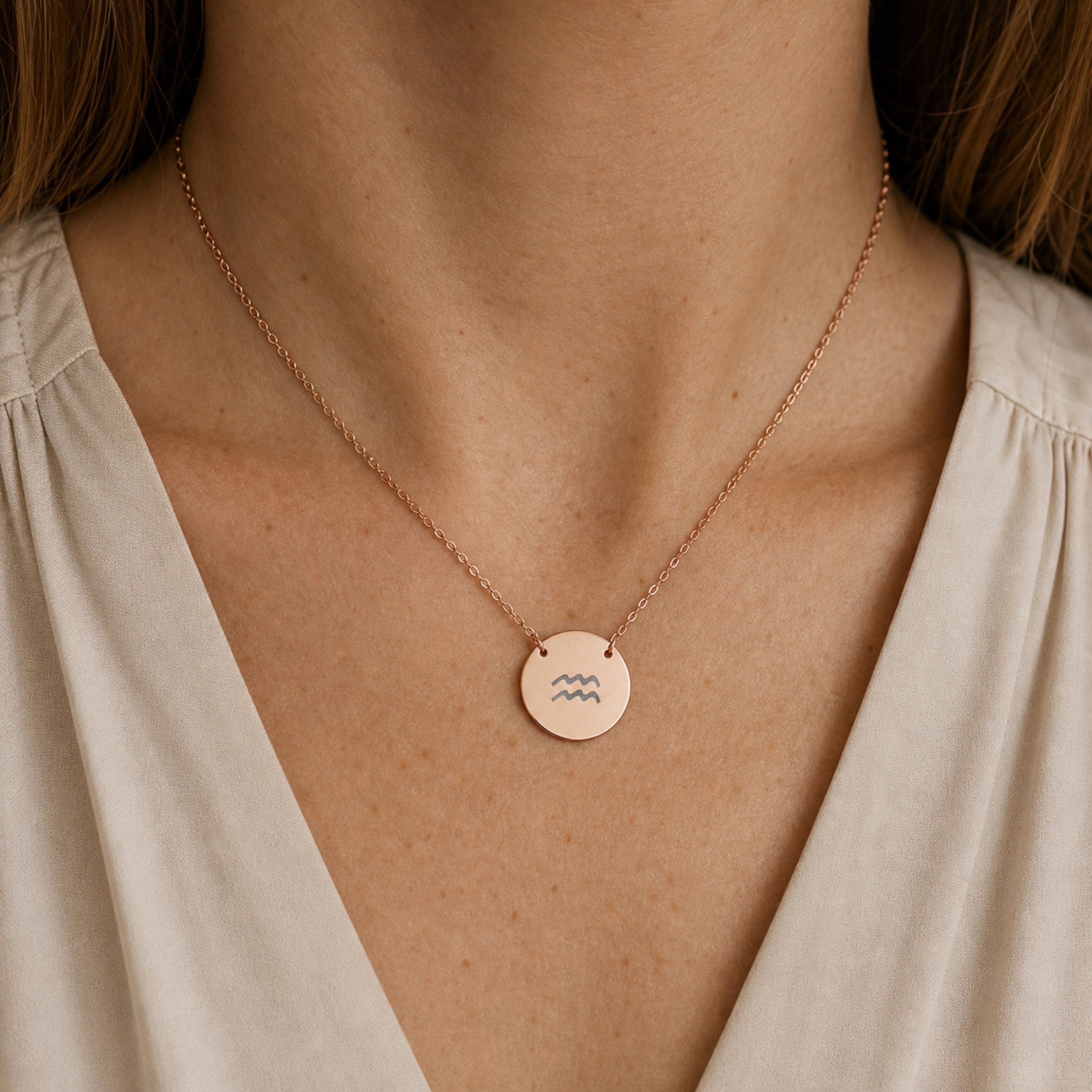 Aquarius zodiac coin necklace worn on model in 18K rose gold PVD - engraved star sign pendant on neckline (AI-generated image)