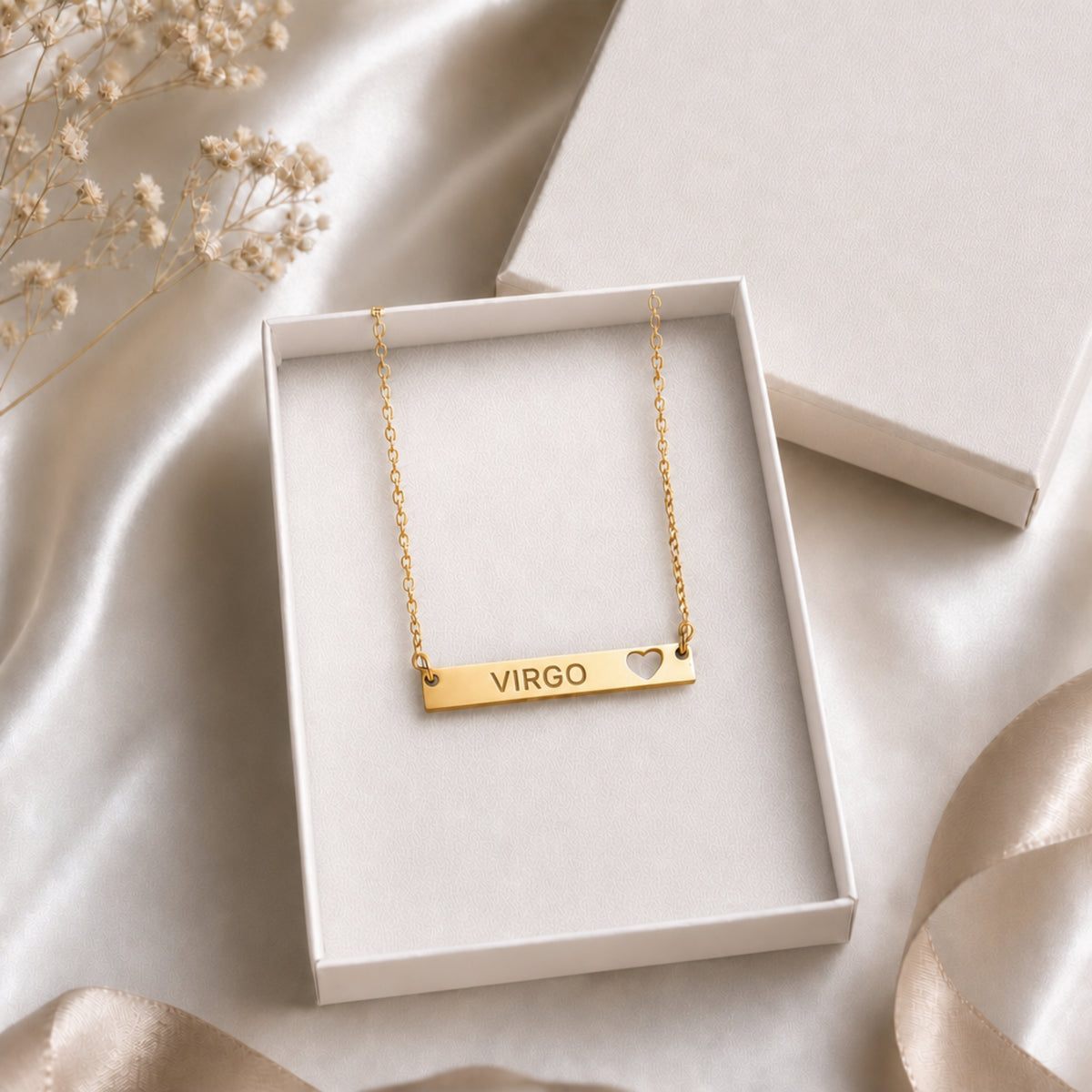 The Virgo zodiac necklace nestled in Memory That Lasts signature cream gift box — 18K Gold cutout heart bar pendant with grey laser-etched VIRGO, satin lining, premium unboxing moment