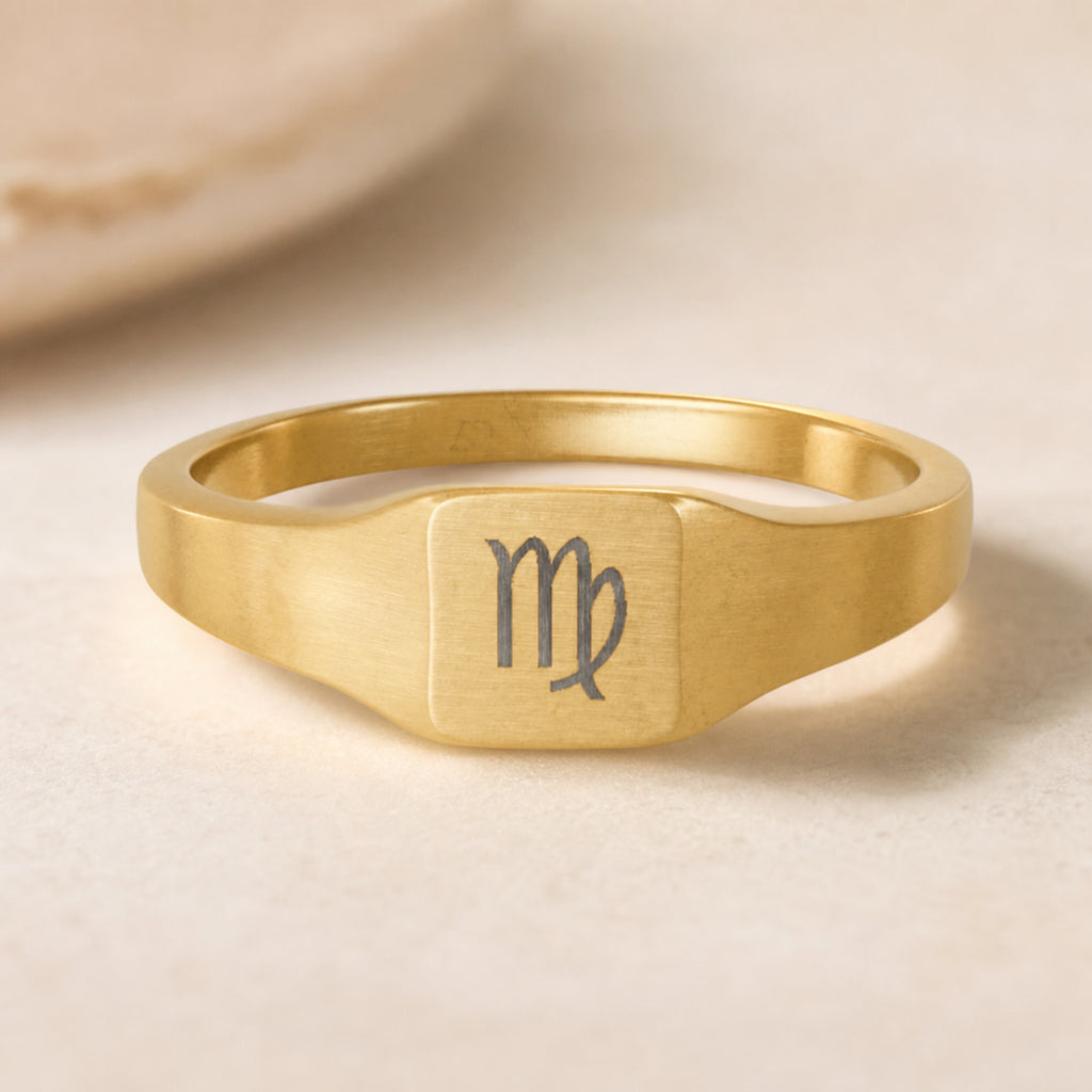 Virgo zodiac square signet ring studio front — clean cream backdrop product shot, 18K gold matte PVD