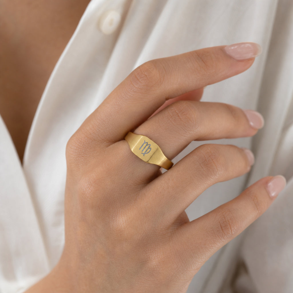 Virgo zodiac square signet ring on finger — model wearing engraved Virgo signet, cream linen lifestyle moment