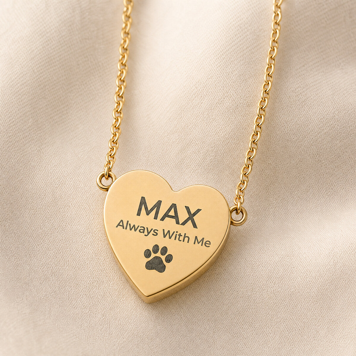 Always With Me heart pendant in 18K gold — close-up on cream linen with custom pet name engraving sample