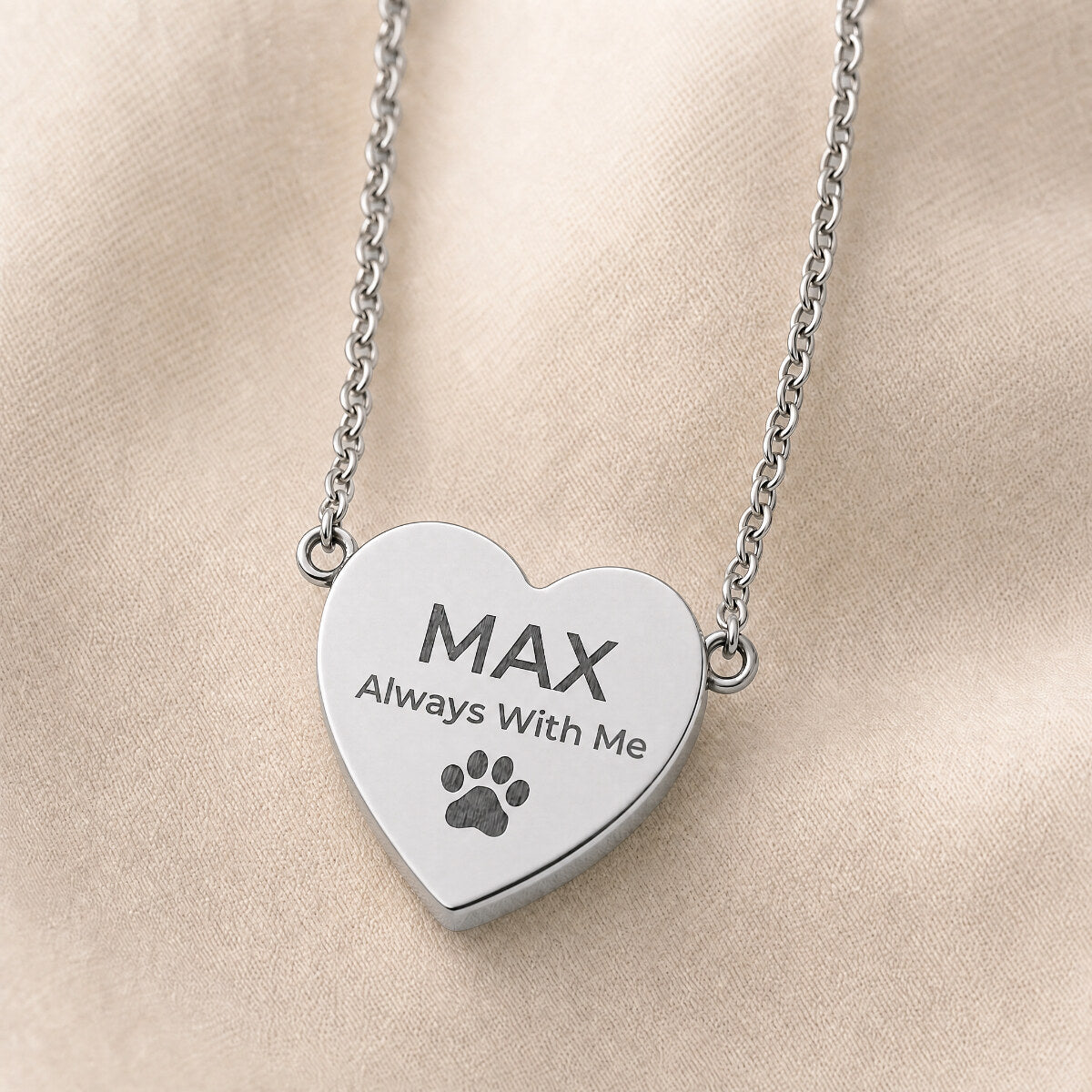 Always With Me heart pendant in stainless steel — close-up on cream linen
