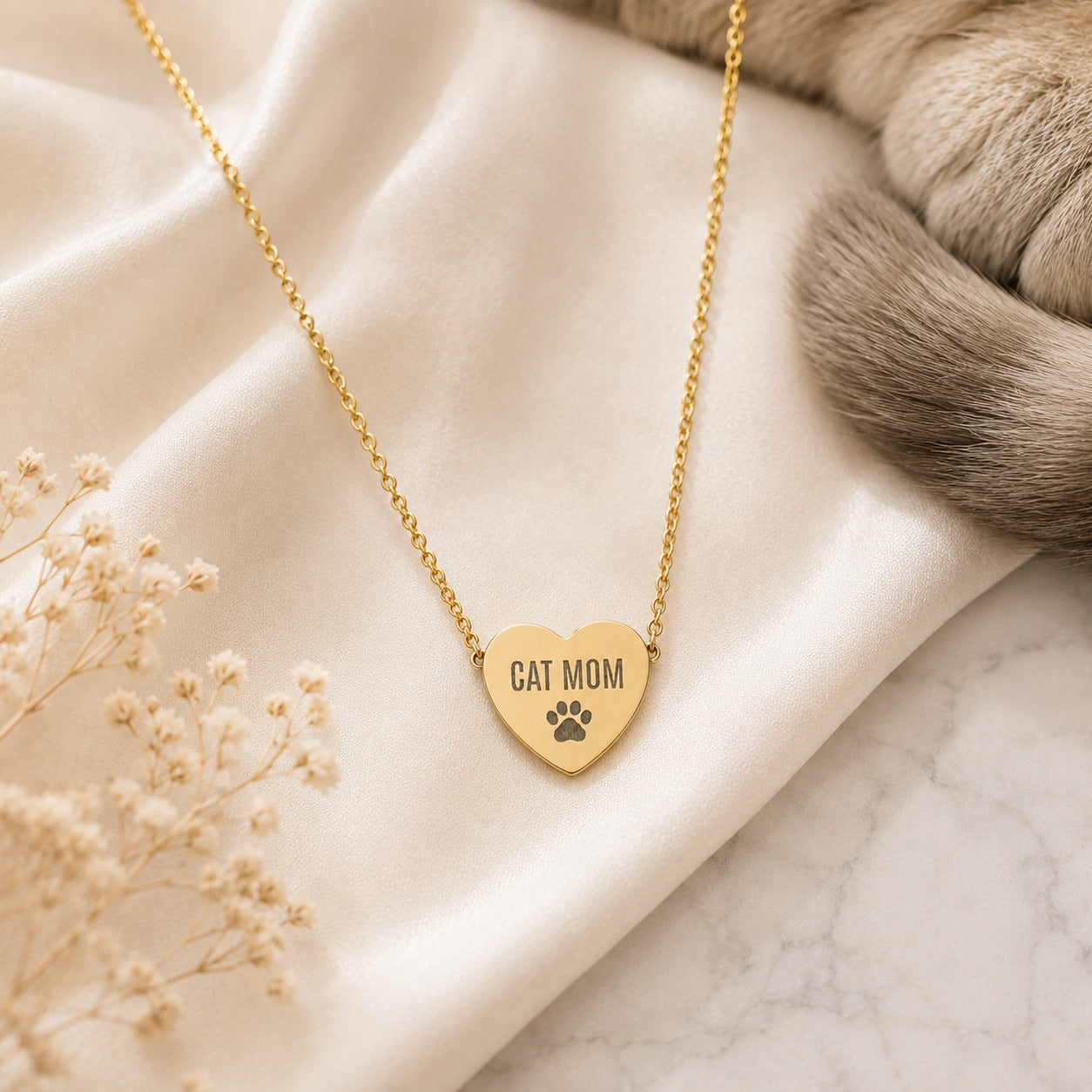 Gold Cat Mom paw print heart necklace flat lay with baby's breath