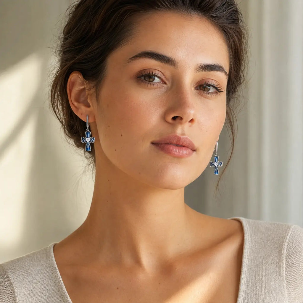 Woman wearing Guardian Angel Cross Earrings with blue enamel crosses and silver huggie hoops