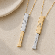 Gold hidden-message slider bar necklace worn at the collarbone, slid open to reveal the hidden name. Memory That Lasts.