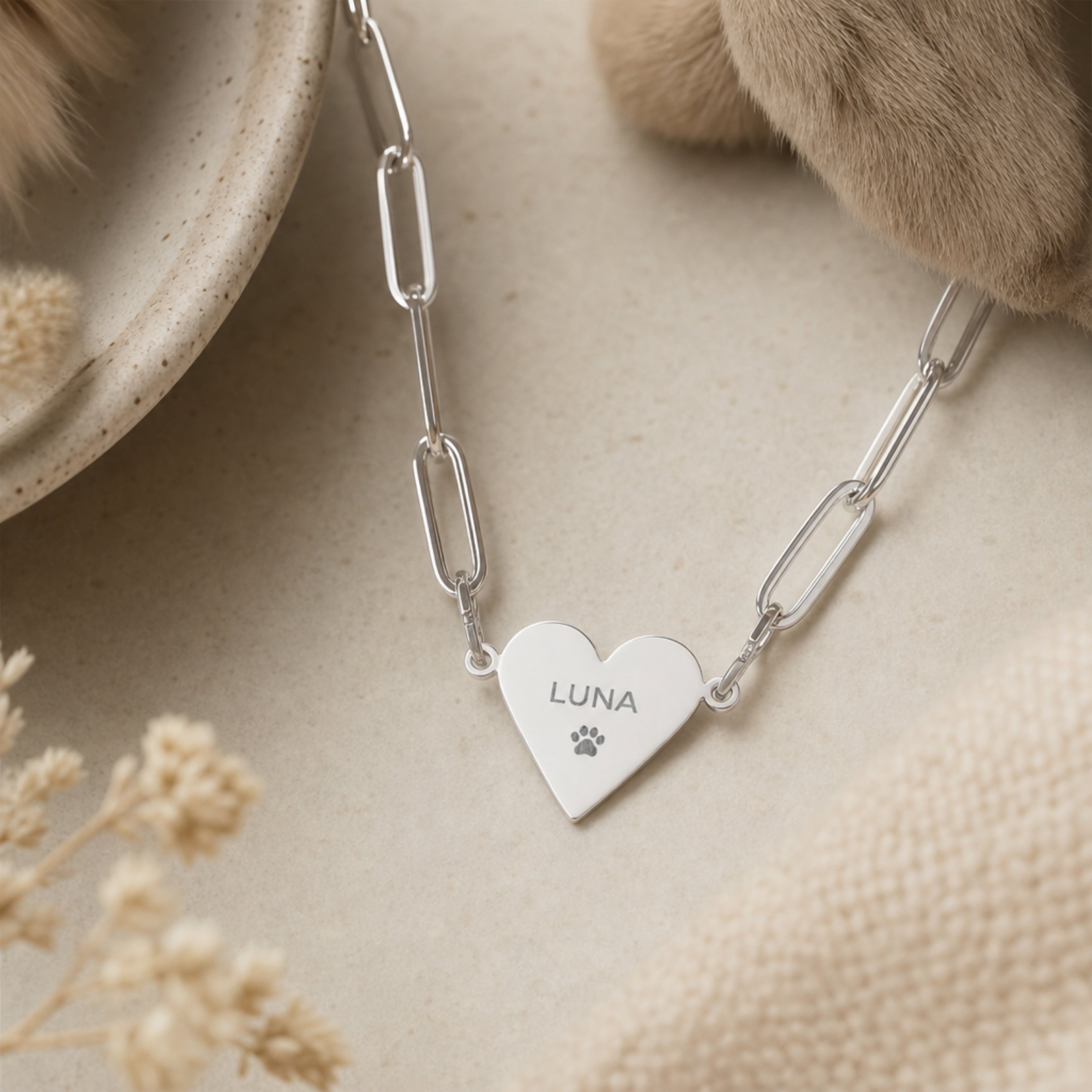 Stainless steel engraved paperclip heart pendant necklace flat-lay on cream linen — a minimalist personalized keepsake for pet parents. Memory That Lasts.