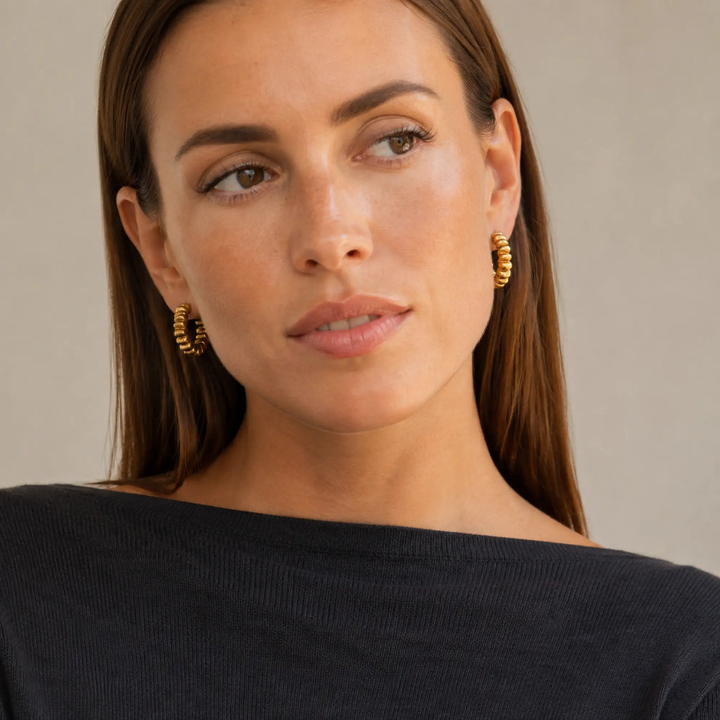Twisted Gold Hoops with sculptural rope texture worn by a woman